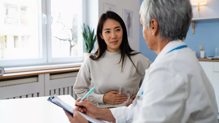 Woman with stomach pain talking to doctor