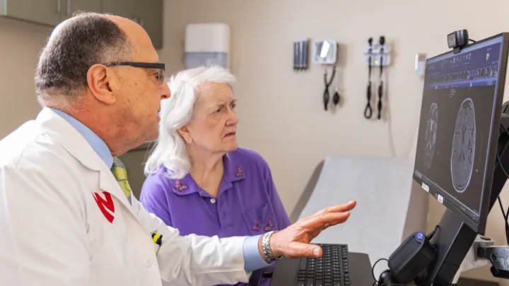 Dr. Fayad looks at brain scans with older female patient